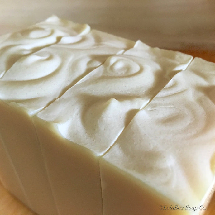 Close up photo of Pure Bliss Milk Bar. Handcrafted soap bars, cream with swirls on top. 