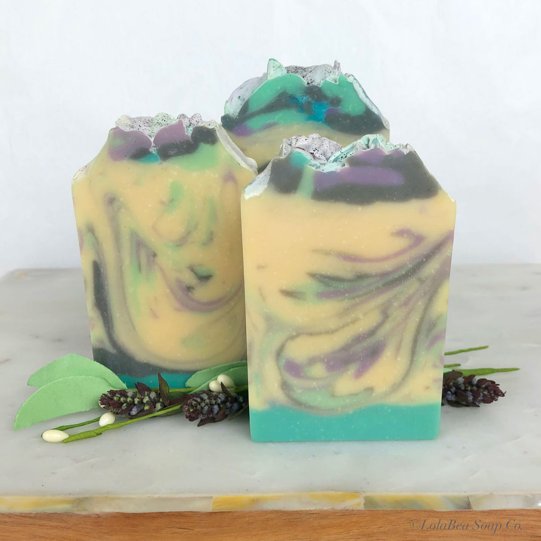 Hand-poured milk infused soap bars. Stripe design in colors of purple, aqua, gray and cream.